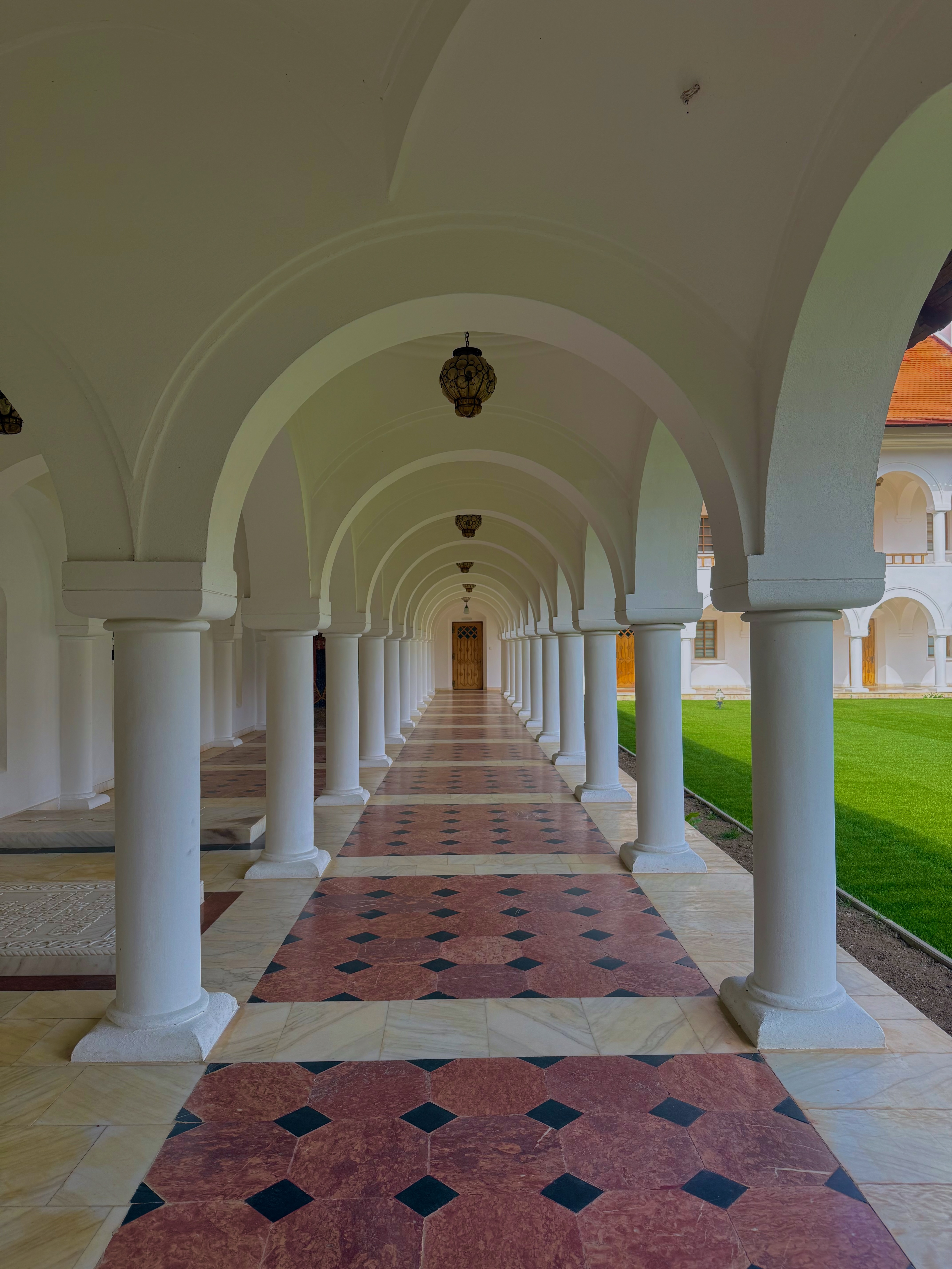 Arched colonnade with marble floors and hanging lanterns