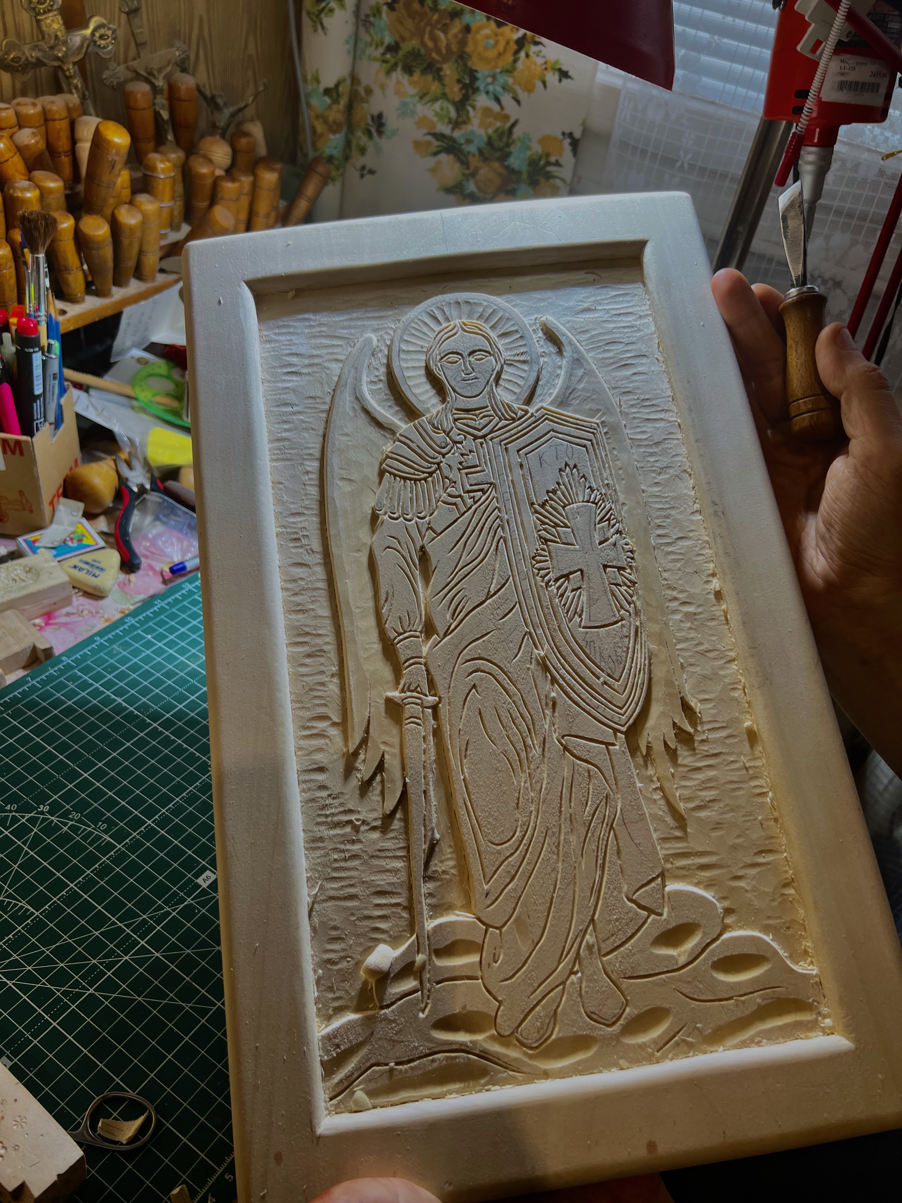 Hand-carved icon of Archangel Michael in a woodworking studio